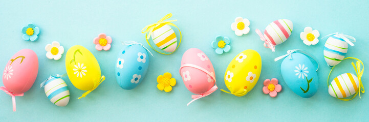 Easter eggs on blue background. Flat lay, long banner format.