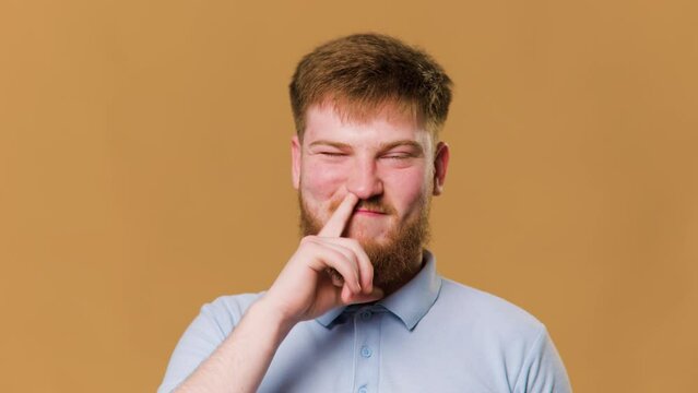 A hilarious studio shot of a young redhead guy looking at camera