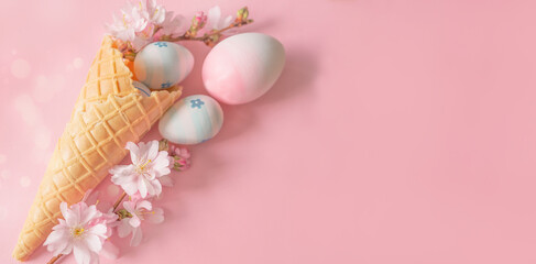 Easter eggs, cherry blossom flowers, ice cream cone on a pink background. Minimal concept