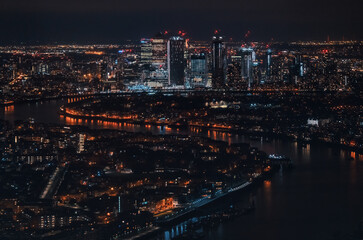 Obraz premium Aerial view of London at night, north eastern part, Isle of Dogs on river Thames, with Canary Wharf financial district