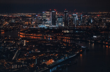 Fototapeta na wymiar Aerial view of London at night, north eastern part, Isle of Dogs on river Thames, with Canary Wharf financial district