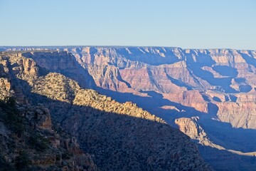 Fototapeta na wymiar Early morning light casts shadows in the deeply eroded Grand Canyon, carved by the Colorado River thousands of feet below