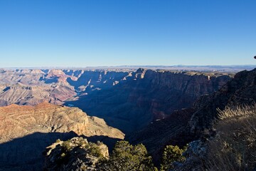 Early morning light casts shadows in the deeply eroded Grand Canyon, carved by the Colorado River thousands of feet below
