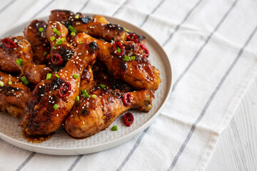 Homemade Easy Sticky Chicken Drumsticks on a Plate, side view.