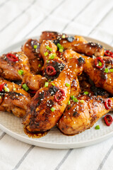 Homemade Easy Sticky Chicken Drumsticks on a Plate, side view. Close-up.