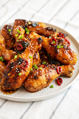 Homemade Easy Sticky Chicken Drumsticks on a Plate, side view. Close-up.