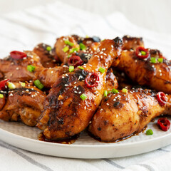 Homemade Easy Sticky Chicken Drumsticks on a Plate, side view. Close-up.