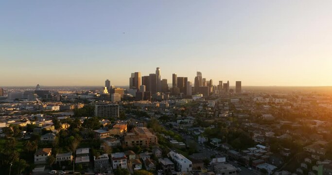 Aerial of downtown Los Angeles in dawn, sunset in California, skyscrapers and office buildings, golden light. Cinematic urban aerial time lapse of downtown Los Angeles city skyline with skyscrapers. 