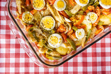Gomes de sa codfish roasted in olive oil with tomatoes, peppers, onions, boiled eggs and oregano....