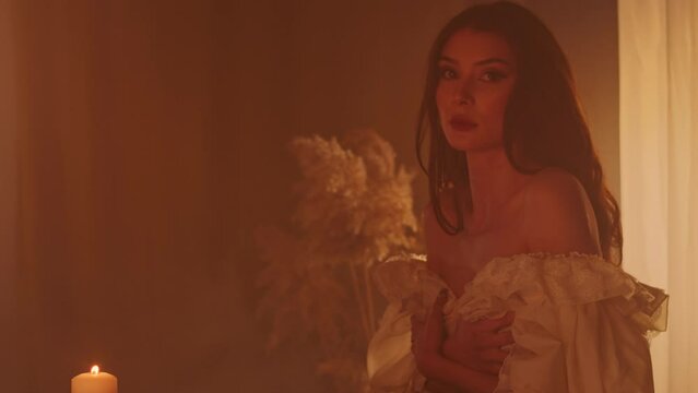 A girl seeks the guidance of pagan gods with divination by candlelight. As the night burns on, she transforms into a water nymph in a white dress