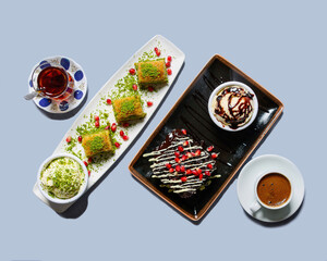 Fototapeta na wymiar Top view of Turkish sweets, baklava, ice cream, turkish coffee and turkish tea on light blue background