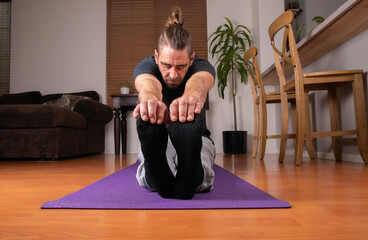 Male Stretching at home in sweats