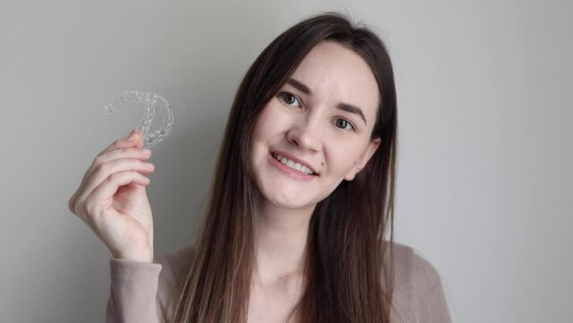 A young girl uses aligners to straighten her teeth