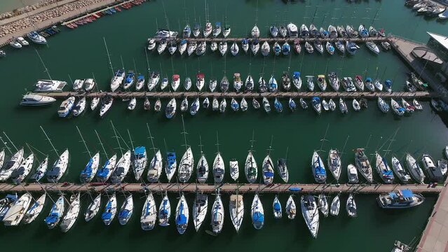 Fly over Boats and small sailing Yachts docked in a beautiful marina