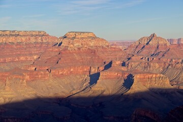 Bright desert sunlight shines down on the Grand Canyon, casting shadows on every crease and layer...