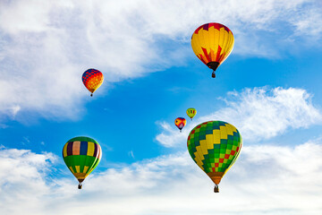 Colorful hot air balloons flying in the blue sky with white clouds