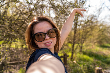 beautiful woman taking selfie outdoors during a happy walk in the countryside