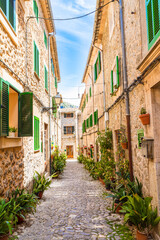 Fototapeta na wymiar Stone paved narrow street, in Valdemossa medieval village, Mallorca, Balearic Islands, Spain