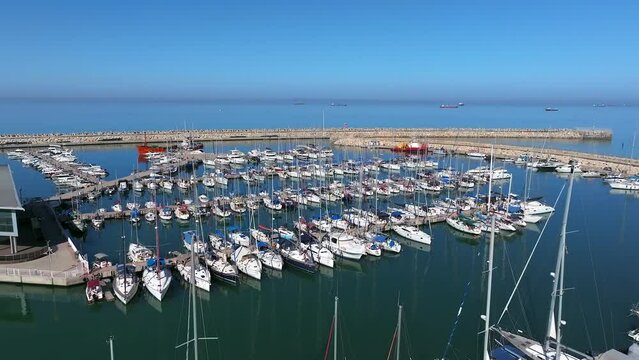 Fly over Boats and small sailing Yachts docked in a beautiful marina