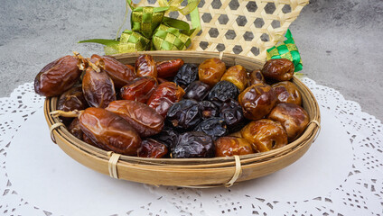 Set of various dates in bamboo basket over cement texture background. selective focus