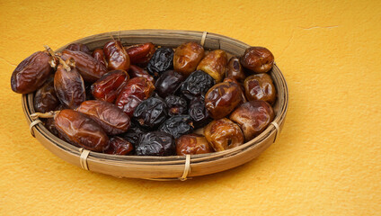 Various of dried dates or kurma in bamboo basket. selective focus