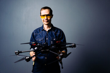 Engineer holding fpv racing kamikaze drone bomber on blue background. Starting motors