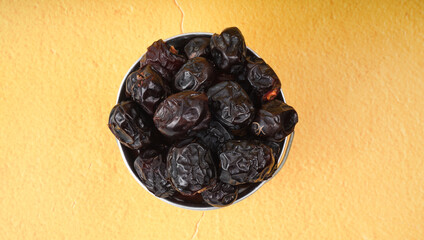 Ajwa Kurma or Dried date fruits in a metal mini-bucket.
