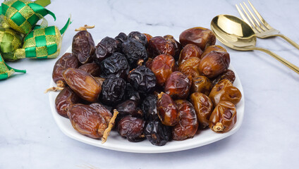 Different types of Dates Piled on White Plate. selective focus