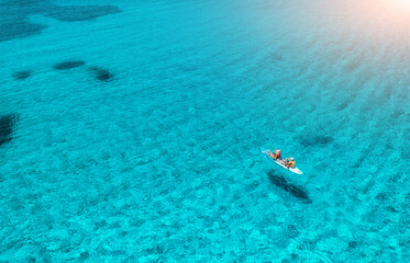Aerial view of kayak with people in blue sea at sunset in summer