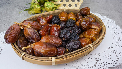 Set of various dates in bamboo basket over cement texture background. selective focus