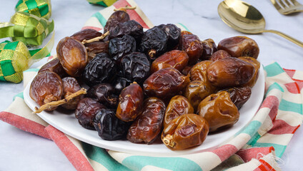 Different types of Dates Piled on White Plate. selective focus