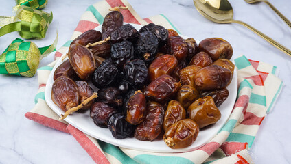 Different types of Dates Piled on White Plate. selective focus