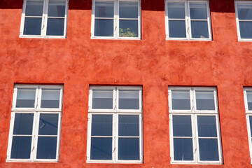 Fototapeta premium Windows in red house facade as background or texture