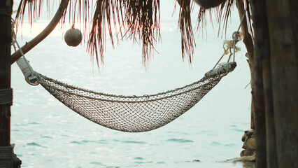 Sea landscape hammock hanging on beach. Beach vacation in hammock