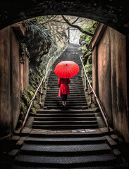 A Japanese girl holding a red umbrella climbing the steps of an ancient staircase in Kyoto, Japan - generative AI