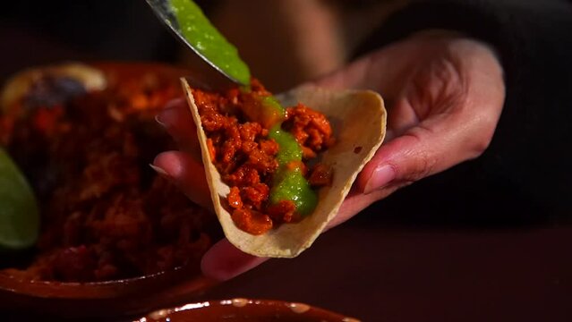 Adding the final touch, fresh salsa is poured over an authentic Mexican Pastor Taco.