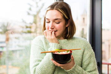 pretty young woman eating a ramen chinese noodles bowl. house interior design