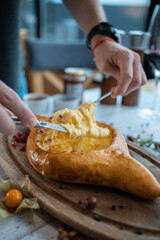person mixing suluguni cheese and egg yolk in georgian adjarian khachapuri