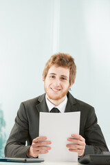 Stylish young man smiles at desk