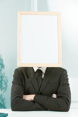 Businessman with a white sign for a head.