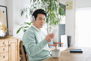 休日に自宅で音楽を聴く50代男性