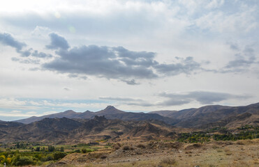 Fototapeta na wymiar View of hilly relief, mountain slopes with sparse vegetation of autumn Caucasus mountains in Armenia