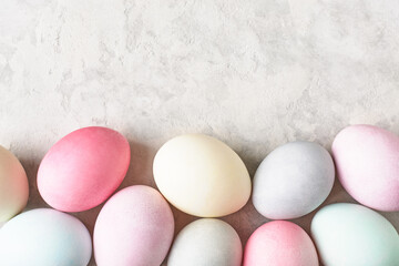 Colorful dyed Easter eggs border. Easter background, pastel pale colors. Copy space, top view.