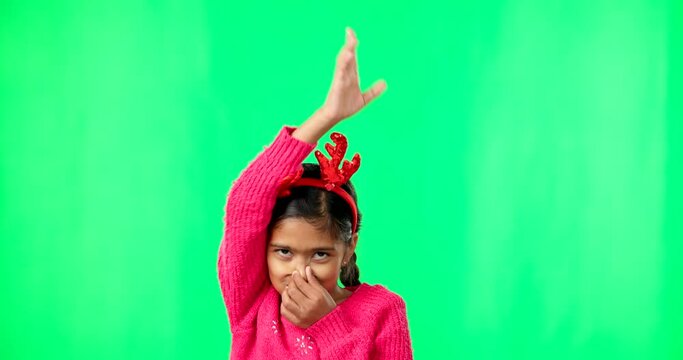 Children, dance and christmas with a girl on green screen background in studio having fun. Kids, party and music with an adorable little female child dancing, full of energy and feeling playful