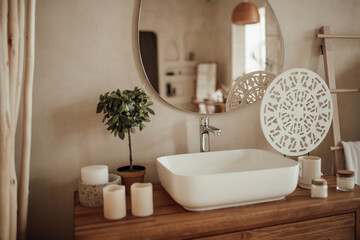 Fototapeta na wymiar Luxury interior of big bathroom at modern african style with oval bathtub in natural lighting