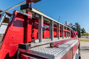 Sturdy extension ladder is firmly secured to the side of the red fire truck