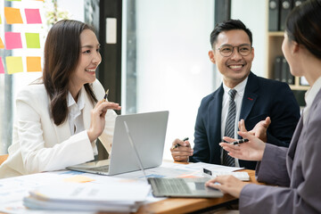 Fototapeta premium Group of asia business people sitting and talking, meeting, presenting, presenting graphs, chatting happily at the office.