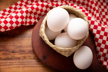 Half a dozen of white chicken eggs on rustic wooden table. Very popular nutritious and economic food product. Table top view image.