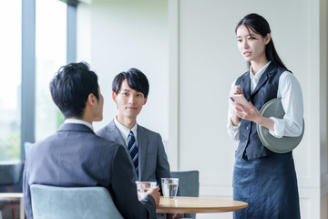 ホテルのラウンジで接客をするウェイトレス