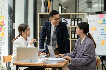 Group of asia business people sitting and talking, meeting, presenting, presenting graphs, chatting happily at the office.
